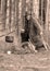 Landscape with a forester in the woods by the fire, a worker drinks tea and warms up by the fire, sepia