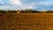 Landscape with fresh plowed arable, sky clouds in background