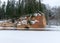 Landscape with frozen river Gauja near Gudu cliffs, view of sandstone cliff from the opposite bank of the river, beautiful red