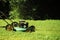 Landscape gardening and landscaping concept. Lawn mower on green grass on sunny day in natural background