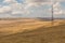 Landscape of the Georgian steppe Udabno in Georgia. Yellow-gold grass, wilde land and blue sky. Endless fields. Mountain in the