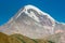 Landscape with Gergeti Trinity Church and mount Kazbek in Georgia