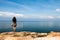 Landscape girl stands on the viewpoint of the vast ocean.