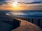 Landscape of golden sunset at the beach illuminating wooden boardwalk