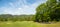 Landscape on a golf course with green grass, trees, beautiful blue sky, panorama