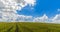 Landscape of green grass fields under blue sky with white clouds, time-lapse movement, nature and relax, climate change