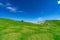 Landscape of green grass and rock hill in spring with beautiful blue sky and white clouds. Countryside or rural view. Nature