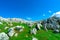 Landscape of green grass and rock mountain in spring with beautiful blue sky and white clouds. Countryside or rural view. Nature