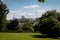 Landscape with green trees against the background of the construction of a new microdistrict.