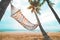 Landscape of hammock with coconut palm tree on tropical beach in summer.