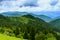 Landscape from height to mountain slopes, blue distance, meadow, house