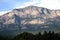 Landscape with high impregnable mountains with rocky vegetation on the slopes under blue cloudless sky on bright sunny day front v