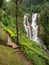 Landscape of highland tea plantation near waterfal cascade in mountain rainforest on Sri Lanka