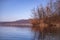 Landscape with a huge lake at the end of the autumn season. rocky mountains and high forests on the distant horizon. silhouettes o