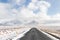 Landscape of Iceland`s golden circle road in winter.Asphalt road go straight to snow capped mountains.empty highway in countrysid