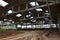 Landscape image of an abandoned industrial hangar with a damaged roof. Photo on wide-angle len