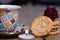 Landscape image of a cup of coffee and a cookies and a rose on a side
