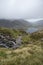 Landscape image of Llyn Idwal in Glyders mountain range in Snowdonia during heavy rainfall in Autumn