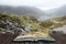 Landscape image of Llyn Idwal in Glyders mountain range in Snowdonia during heavy rainfall in Autumn coming out of pages of open