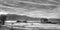 Landscape image of an old barn on a ranch with clouds and mountains