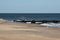 Landscape image of one of the jetties on the beach with sandpipers and seagulls in Rehoboth Delaware.