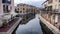 A landscape including buildings alongside a canal