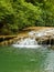 Landscape of incomparable natural beauty with a small waterfall on the Bresque river surrounded by green nature