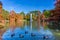 Landscape with lagoon and fountain in the Retiro Park. Water sources. Trees in autumn.