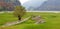 Landscape of Lake Corlo against the background of ruins and a green meadow.