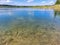 Landscape of lake and forest in the far and texture of crystal clear light Blue and green transparent water