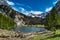 Landscape with lake high in mountains with partial snow