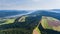 Landscape with lake, hills and farmland. Drone view from above