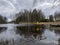 Landscape by the lake, large withered tree silhouette in the water, wooden footbridge in the water