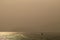 Landscape of lake in the morning with glittering sun light on water surface and long tailed boats running under smog sky.