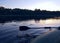 Landscape with lake surface and fragment of paddle of inflatable boat.