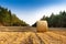 Landscape of a large hay field with numerous straw bales