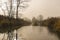 Landscape of late autumn, calm river covered with first ice,