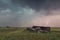 Landscape with lightning striking behind dead tree trunk