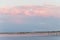 Landscape long bridge over a sea plait on a beautiful pink sunset