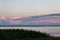 Landscape long bridge over a sea plait on a beautiful pink sunset