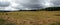 Landscape with many hay rolls on rural filed in the cloudy weather on last summer days