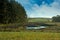 Landscape with meadows and a wild pond in autumn