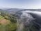 Landscape misty panorama. Fantastic dreamy sunrise on rocky mountains with view into misty valley below. Foggy clouds above