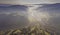 Landscape misty panorama. Fantastic dreamy sunrise on rocky mountains with view into misty valley below. Foggy forest hills. View