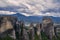 Landscape of monasteries of Meteora in Greece in Thessaly at the early morning. Cliffs of Meteora opposite a morning cloudy sky ba