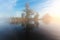 Landscape of morning nature on lake with blue sky, clouds, fog mist and lonely tiny island with trees