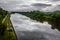 Landscape of Moscow channel. View from the bridge of the Rogachevskoe highway in Dmitrov. Cloudy sky reflects in river waters