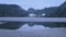 Landscape of mountain, forest and half frozen lake in Switzerland. Reflection in water.