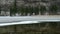 Landscape of mountain, forest and half frozen lake in Switzerland. Reflection in water.