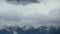 Landscape of mountain, sky and clouds. Time lapse of dark clouds and mist over snowcapped mountains.